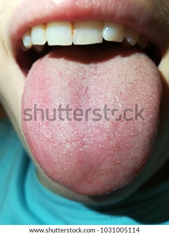 Tongue exposed out of mouth Royalty-Free Stock Photo #1031005114
