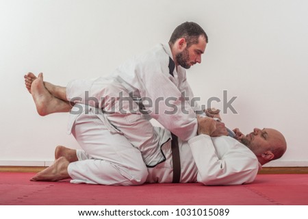 Brazilian jiu-jitsu training demonstration in traditional kimono.BJJ Closed guard position Royalty-Free Stock Photo #1031015089