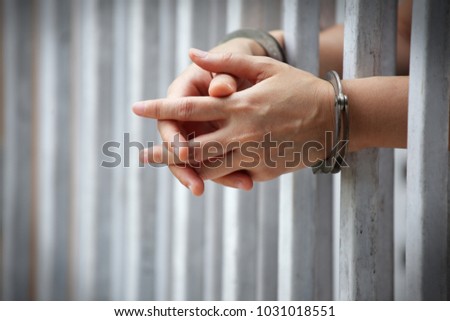 close up of prisoner hands in jail background. Royalty-Free Stock Photo #1031018551