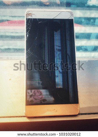 Smart phone isolate on glass wall background have problems screen of the mobile phone broken, crack to reach the inside of the monitor caused drop on the floor until the collapse and damage.