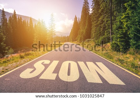 Close up of road marking saying Slow in the mountains