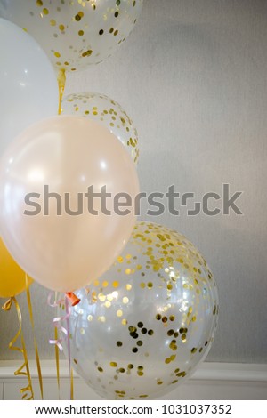 White, yellow and pink balloons are in sunny rooms.