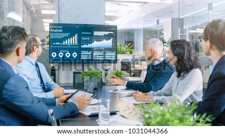 Board of Directors Has Annual Meeting, Diverse Group of Business People in the Modern Conference Room Discuss Statistics and Work Results. In the Background Projector Showing Company Growth. Royalty-Free Stock Photo #1031044366