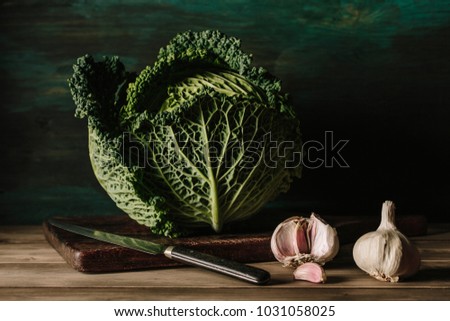 Delicious fresh and big cabbage with garlics in a wooden table.