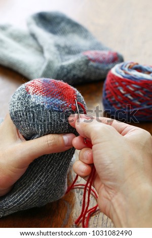 darning socks, repairing holes in socks Royalty-Free Stock Photo #1031082490
