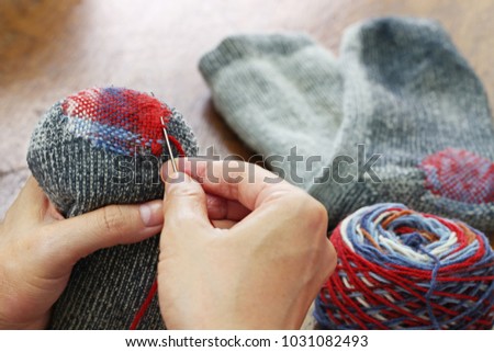 darning socks, repairing holes in socks Royalty-Free Stock Photo #1031082493