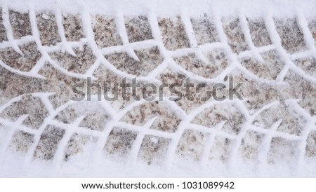Close up of a vehicles tire tread in the snow.