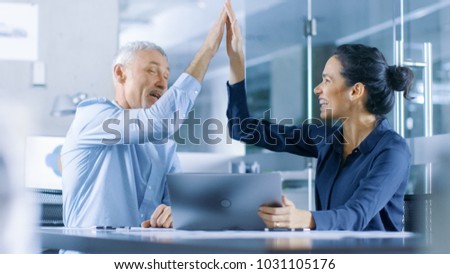 Senior Executive and Young Female Manager Working on a Laptop Win Big and Have Successful Moment, They High Five Each other and are Happy.