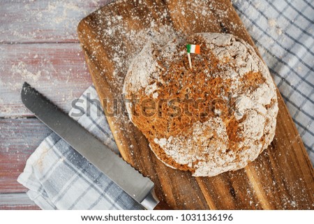 Homemade whole wheat irish soda bread decorated by irish flag and cloverleaf