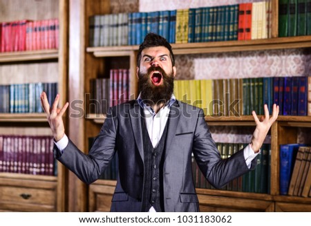 Going crazy, mad and insane, wild, stress and agression, shame, hysteria, accuse, blame, fault, rage, responsibility, uncontrollable agressive angry evil rude man in library Royalty-Free Stock Photo #1031183062