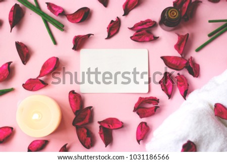 Pink background with dried petals, candle, orchid flower and copy space for your text; beauty, spa or wellness background