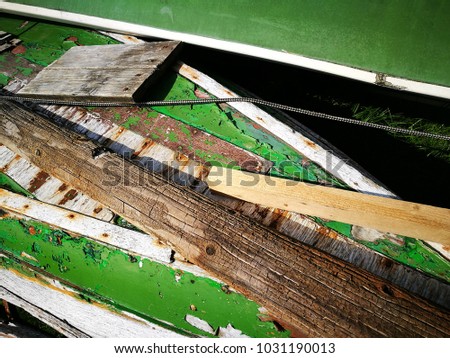 Wreckage of old row boats in white and green color on the bank of the Alpsee in Schwangau in Bavaria, Germany