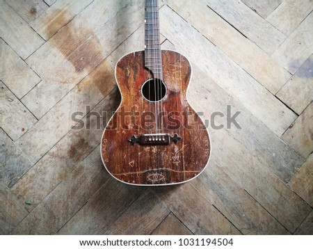 Old acoustic guitar on the wooden floor of an attic in a country house in Rottenbuch in Bavaria, Germany