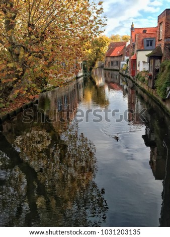 Famous canal or water channel of Bruges that surrounded by historical brick houses with reflection on river in Belgium, Europe. Europe destination concept photo with copy space
