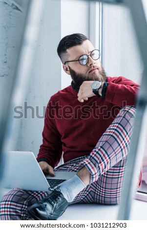 portrait of thoughtful businessman with laptop looking away