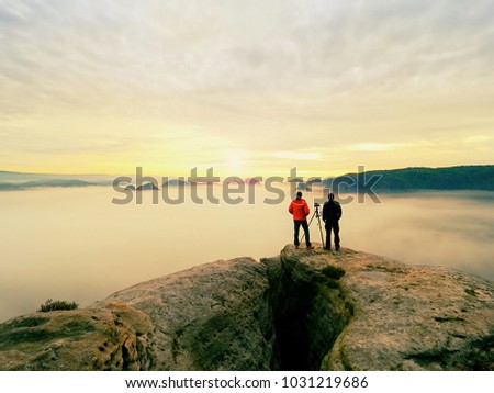 People just taking pictures,  tourists on viewpoint with view to the misty  mountain in morning.