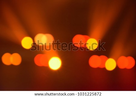 Orange bright bokeh background shining in the dark room horizontally. Light ray visible.