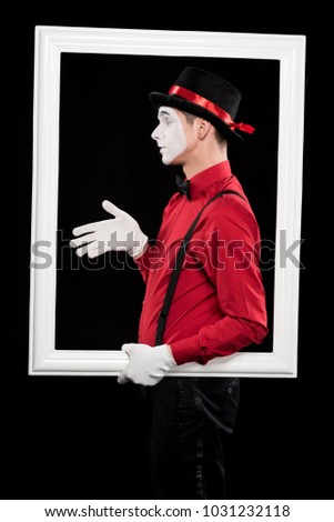 side view of mime showing hand in frame isolated on black