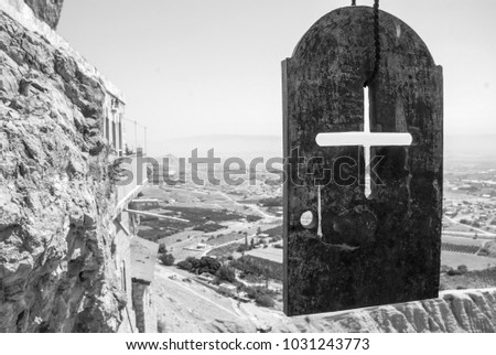 Black and white picture of a cross on a metal plate on the top of Monastery of the Temptation, an Orthodox Christian monastery, located in Jericho, Israel