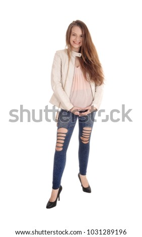 A portrait image of a beautiful young woman in jeans and a white 
leather jacket standing isolated for white background
