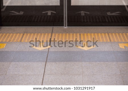 yellow traffic sign on the floor at terminal train station