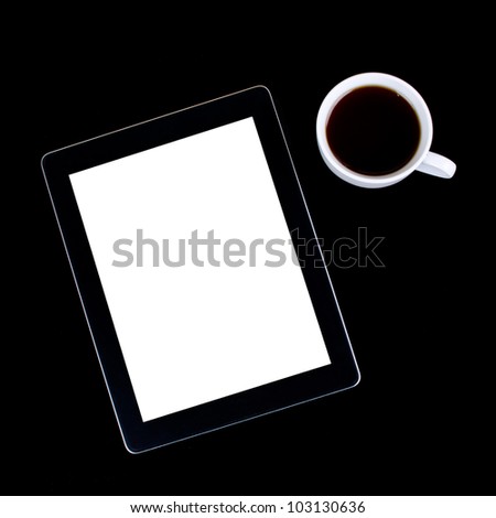 Blank digital black tablet on a desk with empty white screen and cup of coffee