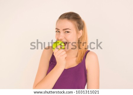 beautiful girl eating a green apple, white background