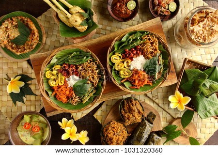 Nasi Campur Bali. Popular Balinese meal of rice with variety side dishes, which are served together with the rice and more as optional extras. Royalty-Free Stock Photo #1031320360