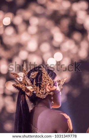 Beautiful Thai Girl with Holiday Makeup wear Thai traditional costume over firework background at the festival. Celebrating woman.
