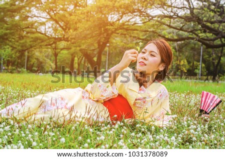 Kimono woman, Young girl wearing Japanese kimono sitting in the park, Kimono is a traditional Japanese clothing