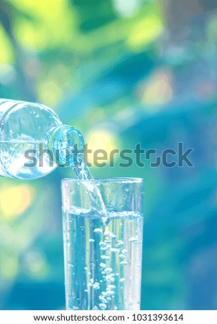 drink water pouring into empty glass with natural green background