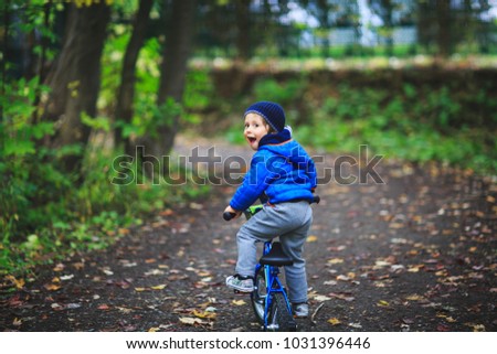 Amazing child on a bicycle at forest road. Child has fun with bicycle. Cute child learning to ride bicycle. Adorable child having fun on his first bicycle. Best pictures for children concept.  