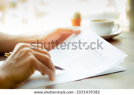 Business man hand holding pen over agreement form Royalty-Free Stock Photo #1031439382