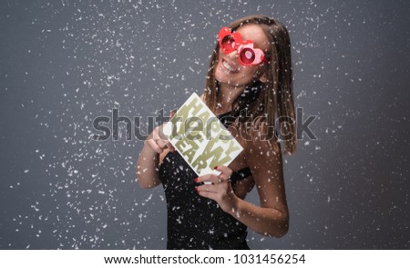 Beautiful woman celebrating New Year with confetti and champagne holding sign. isolated