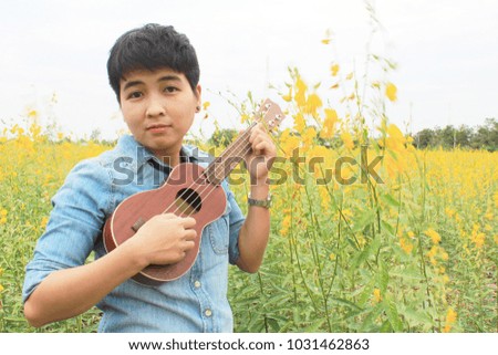 A person playing the ukulele in the atmosphere of nature.