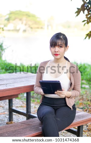 Asian woman look at tablet.