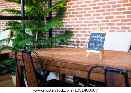 The living room was decorated with brick walls, trees, black steel chairs, wooden table and blackboards, written in three languages, which means "For 4 People UP!".