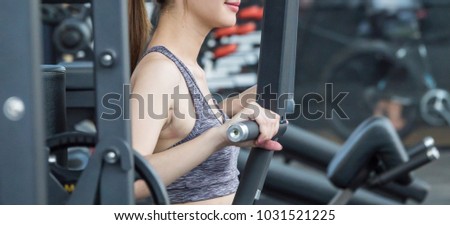 Asian sport woman doing some exercises with gym equipment in fitness club. 