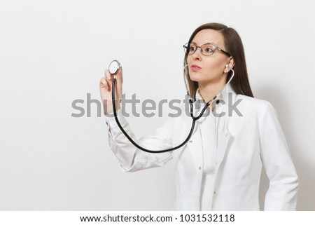 Concentrated confident experienced beautiful young doctor woman using stethoscope isolated on white background. Female doctor in medical gown glasses. Healthcare personnel, health, medicine concept