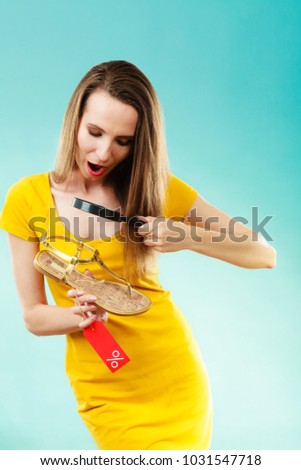 Good shopping summer sale concept. Fashionable woman choosing shoes searching through magnifying glass, discount red label with percent sign in hand