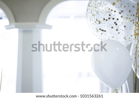White, yellow and pink balloons are in sunny rooms.
