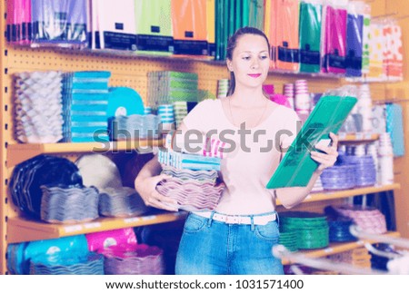 Cheerful girl demonstrates dishes, towels, napkins, disposable cups and tablecloth
