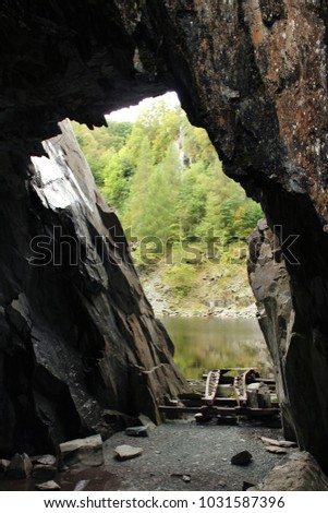 abandoned quarry cave in the lake district cumbria with industrial remains in bottom 