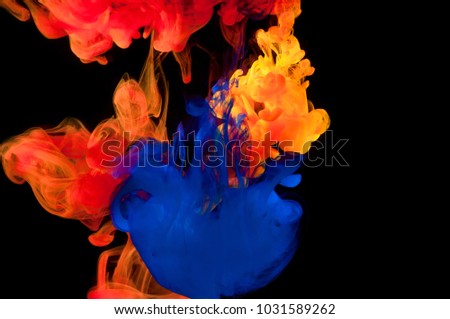 Color paint in water on a black background