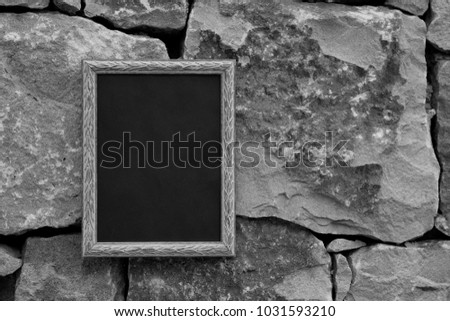 Black and white photo frame on a stone wall. mock up.