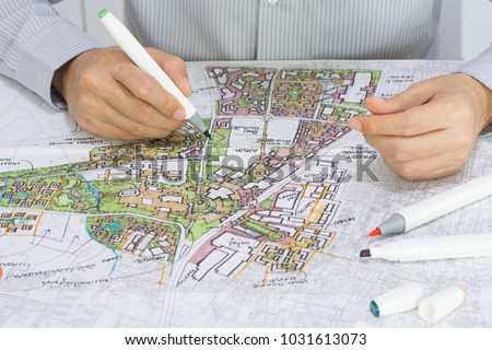 master plan of urban landscape design or urban architecture drawing by man's hand with color marker pen on white paper and group of color marker pens, with English and Thai language in plan drawing Royalty-Free Stock Photo #1031613073