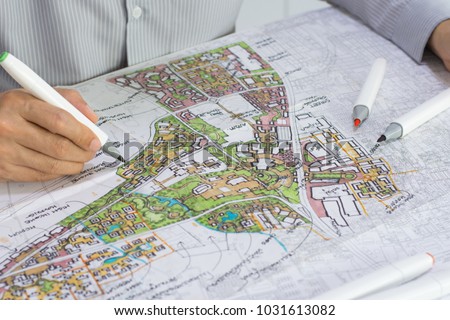 master plan of urban landscape design or urban architecture drawing by man's hand with color marker pen on white paper and group of color marker pens, with English and Thai language in plan drawing Royalty-Free Stock Photo #1031613082