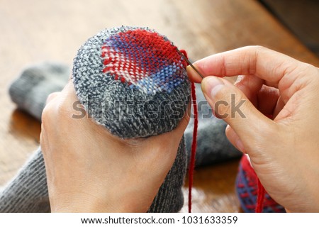 darning socks, repairing holes in socks Royalty-Free Stock Photo #1031633359