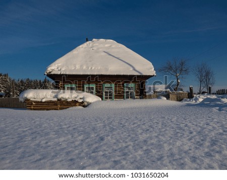 Old wooden house around which snow fell