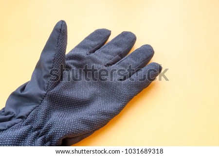 Black Winter Gloves with Rough Texture on Orange Background